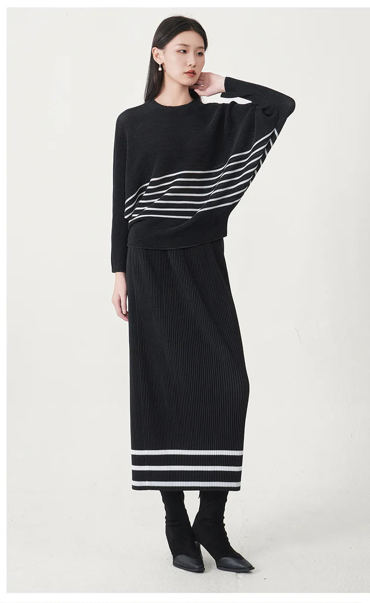 A trending women's clothing item for 2026: a matching black batwing-sleeved striped T-shirt and straight-cut skirt set by Miyake