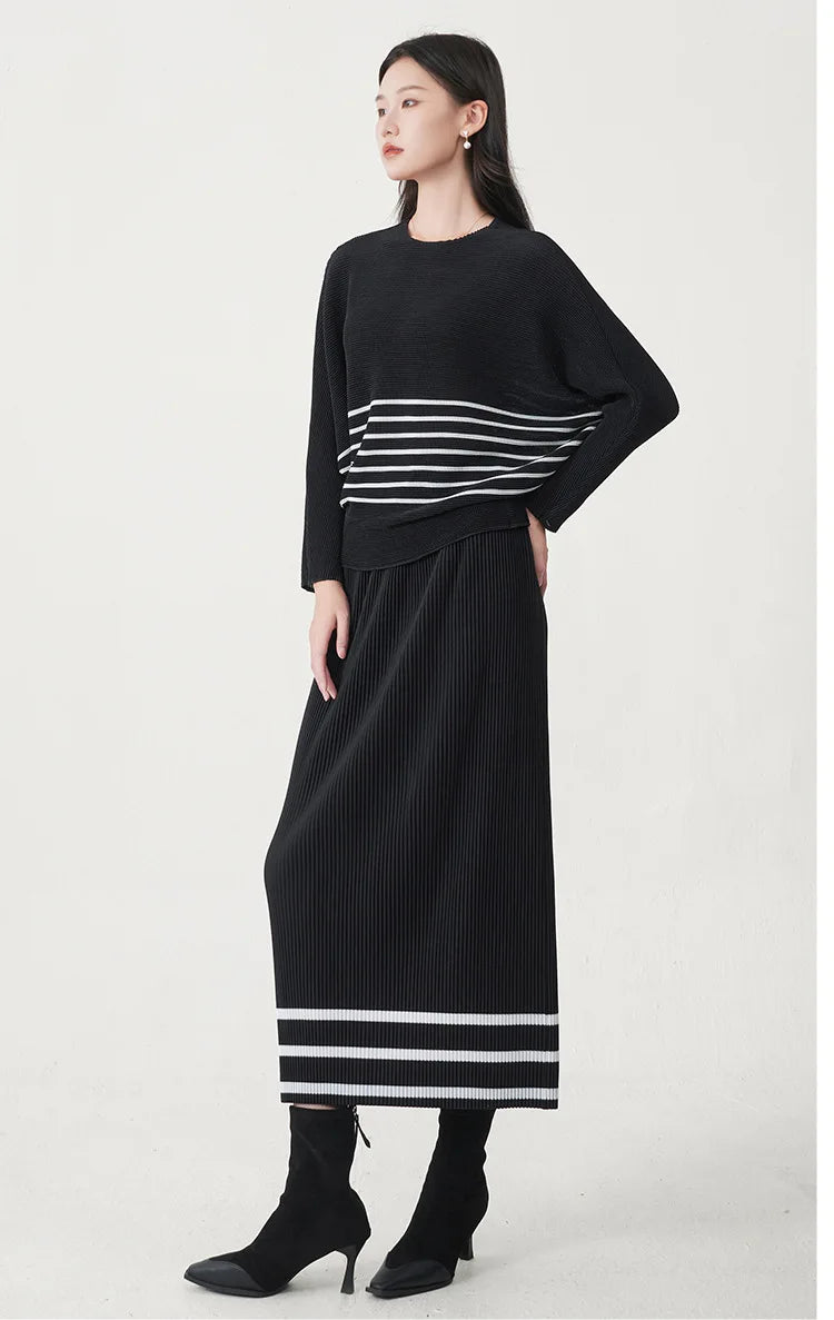A trending women's clothing item for 2026: a matching black batwing-sleeved striped T-shirt and straight-cut skirt set by Miyake