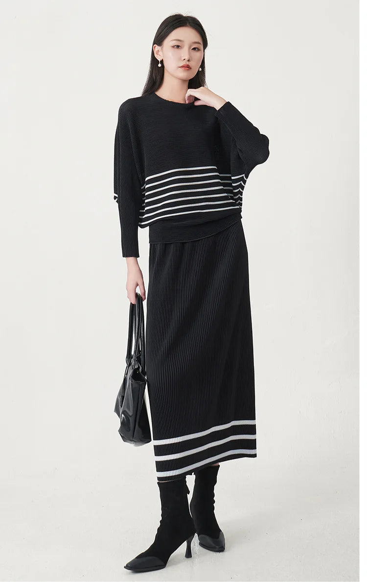 A trending women's clothing item for 2026: a matching black batwing-sleeved striped T-shirt and straight-cut skirt set by Miyake